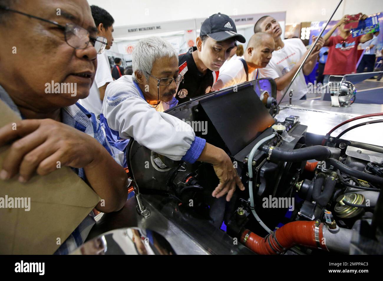In this Oct. 12, 2017, photo, drivers and visitors look at a Euro 4 compliant engine fitted on a
