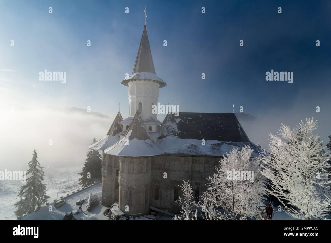 Monastery church in the snow. Carpathian mountain village in Transylvania, Romania Stock Photo