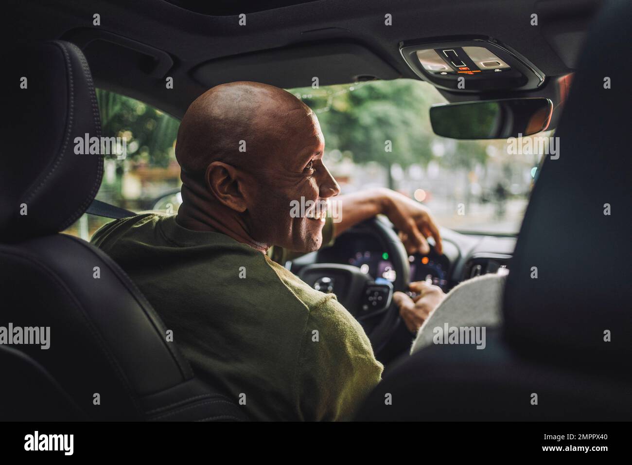 Smiling mature man looking away while sitting in car Stock Photo