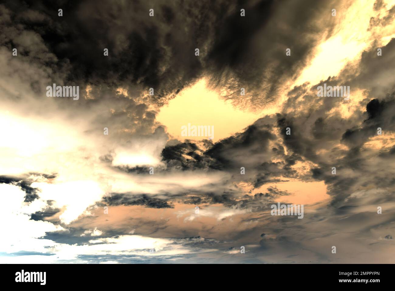 Abstract photography of clouds on a bright orange from the sun dark gloomy sky Stock Photo