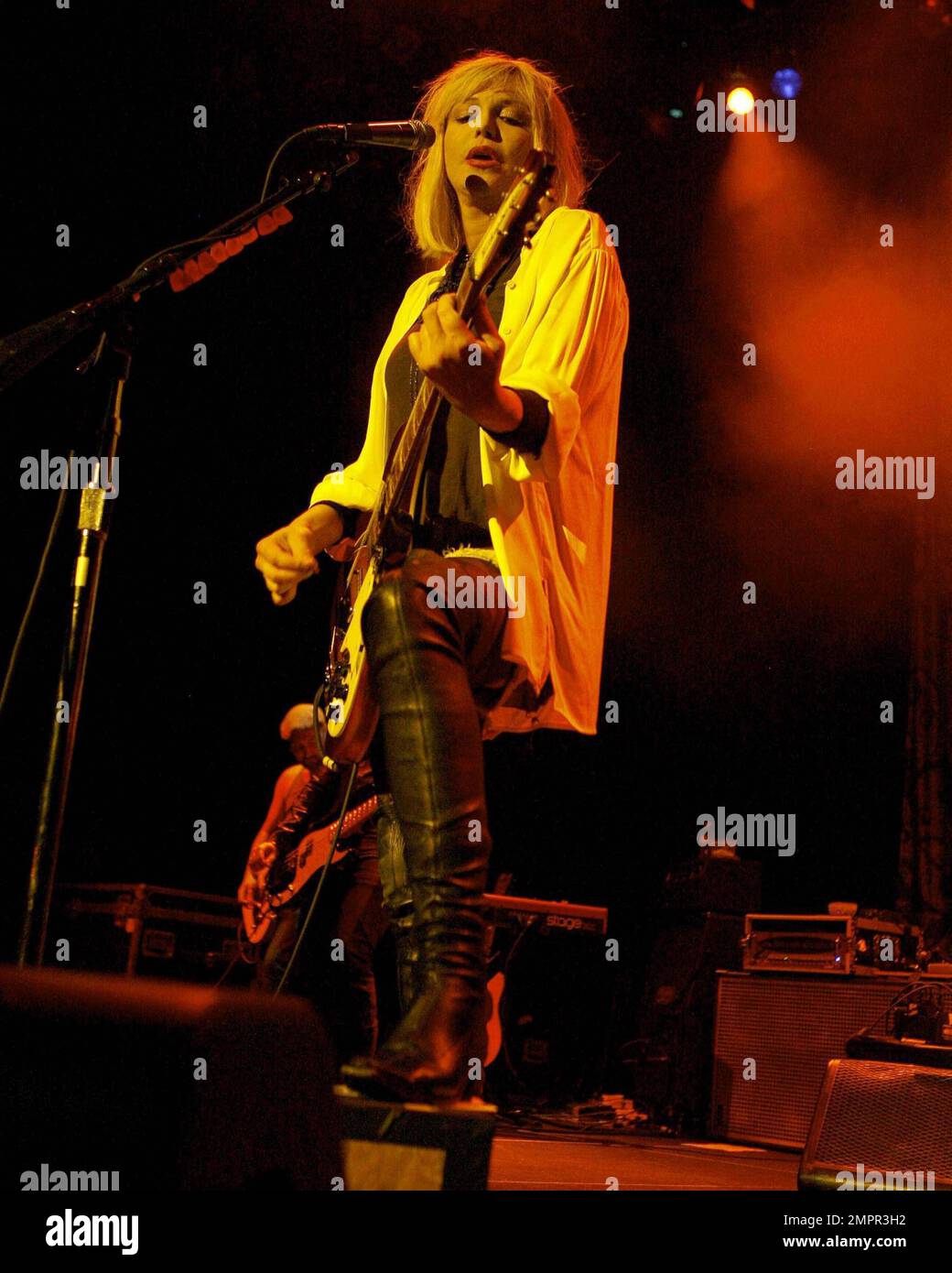 Courtney Love smokes a cigarette on stage as she performs live in ...