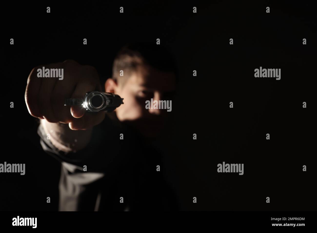 Professional killer on black background, focus on gun Stock Photo - Alamy