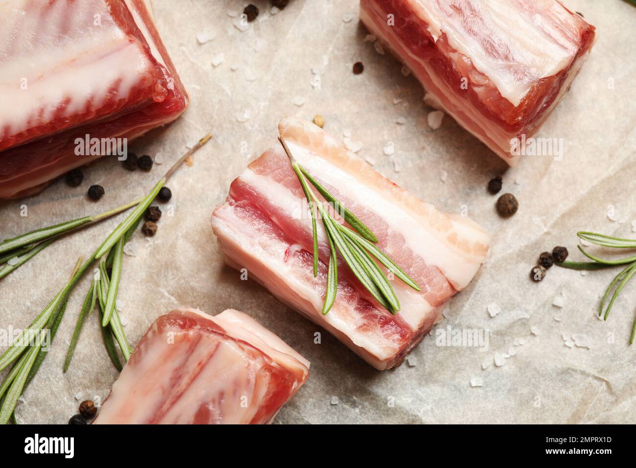 Raw ribs with rosemary and spices on parchment paper, flat lay Stock