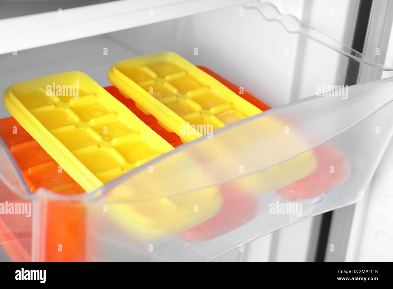 https://c8.alamy.com/comp/2MPT1TR/different-plastic-ice-cube-trays-in-fridge-2MPT1TR.jpg