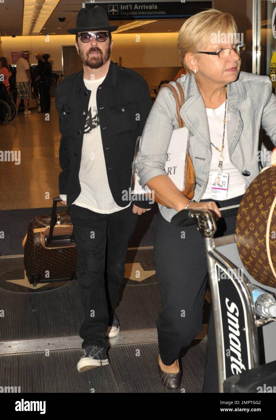 Exclusive!! Vince Neil arrives at Palm Beach International Airport and  strolls along with a bodyguard who carries his Louis Vuitton luggage. His  arrival is in advance of CrŸe Fest featuring Mštley CrŸe