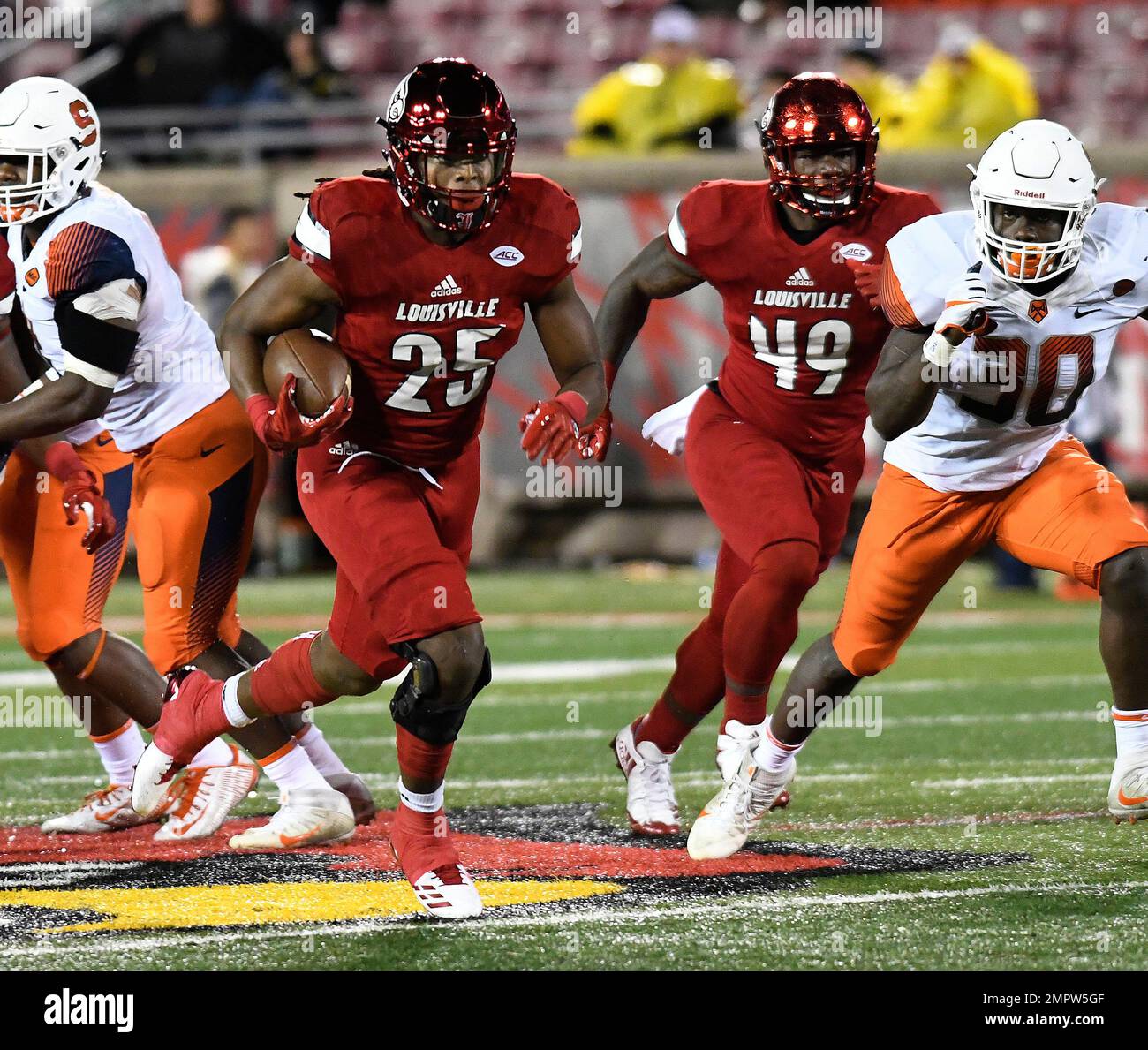 Louisville running back Dae Williams (25) runs through a hole in the