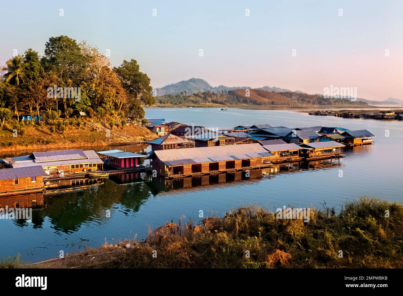 Floating homes and guesthouses on Vajiralongkorn Lake in early morning light, Sangkhlaburi, Thailand Stock Photo