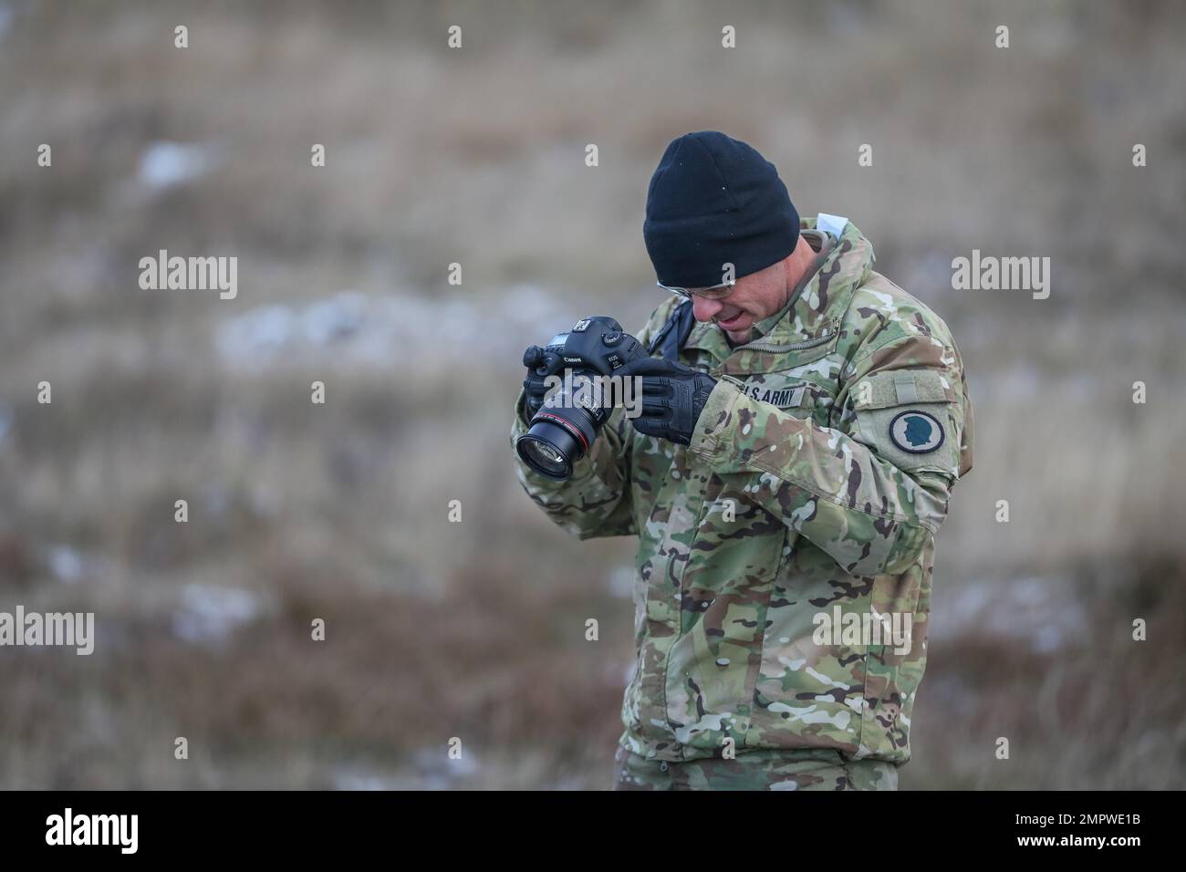 U.S. Army Staff Sgt. Matthew Foster, a mass communication specialist assigned to 117th Mobile Public Affairs Department (117th MPAD), operationally controlled by the 1st Infantry Division (1 ID), reviews photos taken during a live fire exercise rehearsal at Bemowo Piskie Training Area, Poland, Nov. 18, 2022. The 117th MPAD is among other units assigned to the 1 ID, proudly working alongside NATO allies and regional security partners to provide combat-credible forces to V Corps, America's forward deployed corps in Europe. Stock Photo