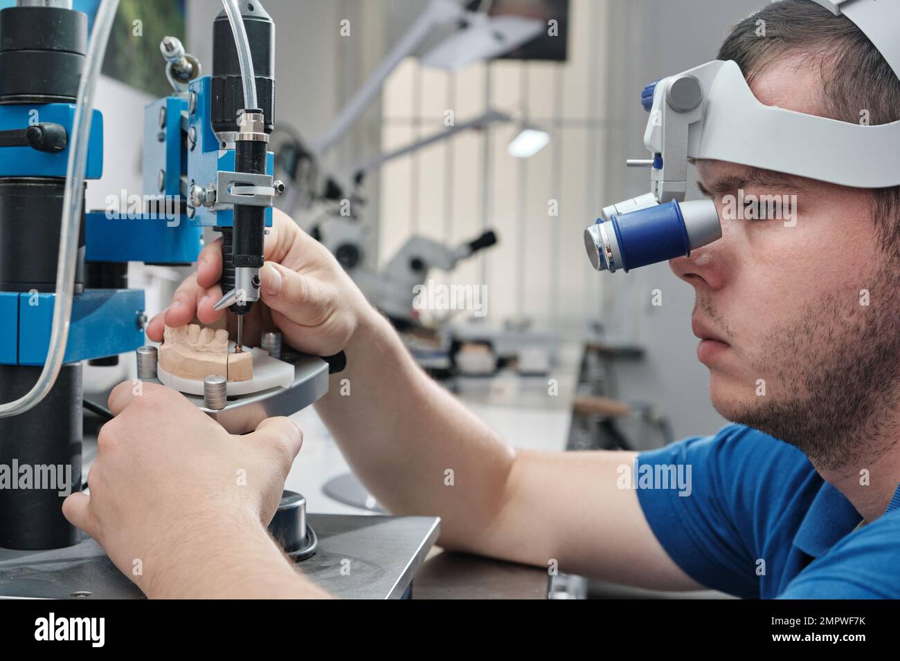 Dentist with binocular magnifying glasses working in dental clinic. The