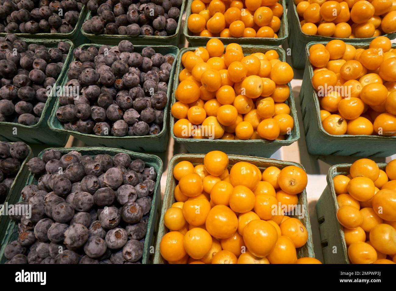 Containers of golden berries and blueberries for sale in the Granville Island Public Market, Vancouver, BC, Canada Stock Photo