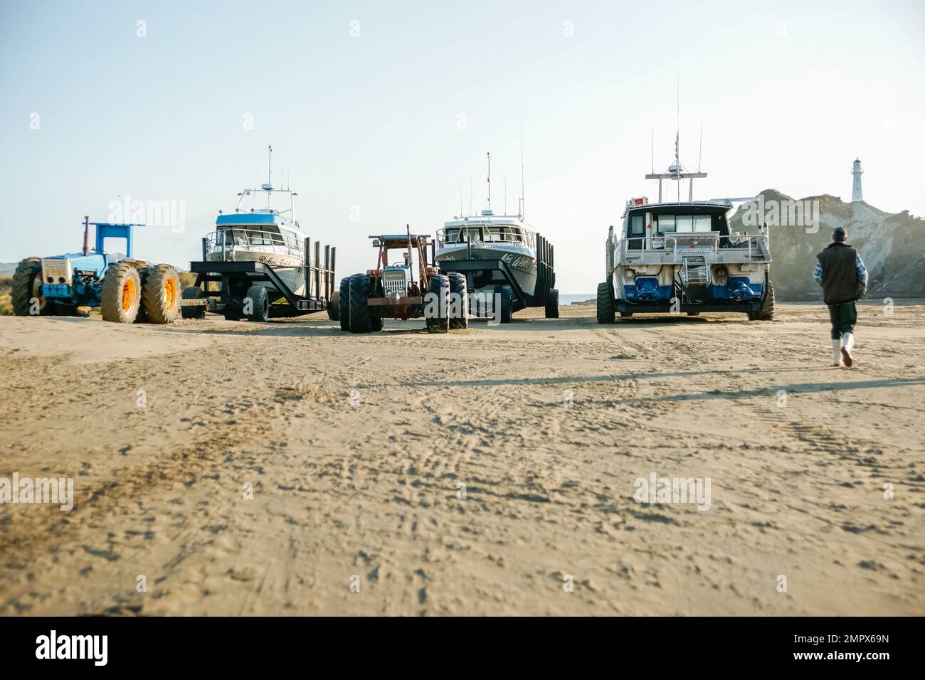 Castle Point, New Zealand - October 5 2010; Four fishing boats and tractors lined up on beach ready to launch Stock Photo