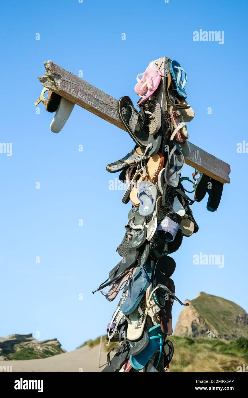 Castle Point New Zealand - October 5 2010: Collection lost footwear attached to cross on beach, Home of Lost Soles vertical composition. Stock Photo