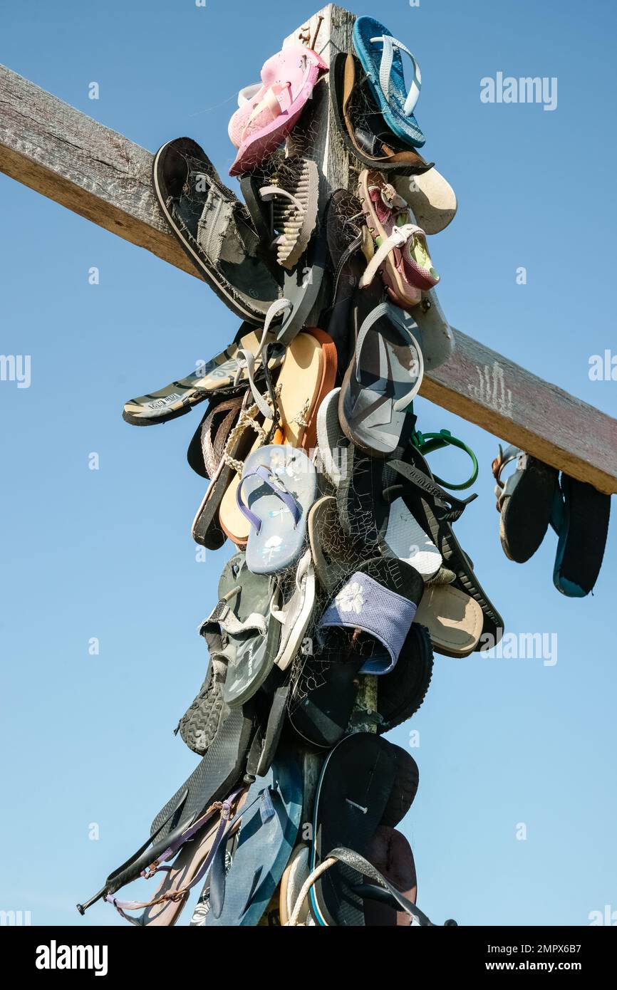 Castle Point New Zealand - October 5 2010: Collection lost footwear attached to cross on beach, Home of Lost Soles vertical composition.closeup. Stock Photo