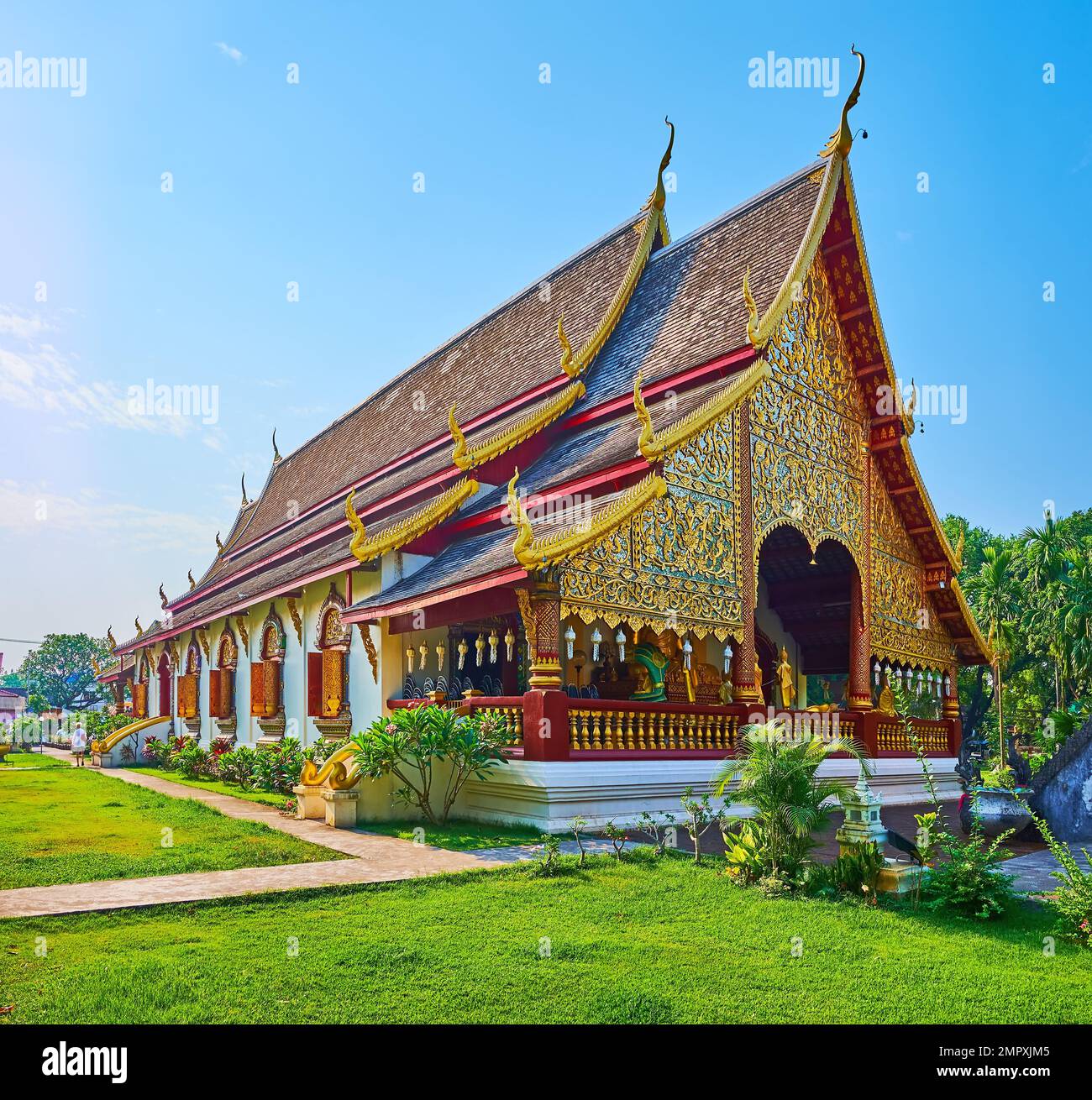 The richly decorated Viharn of Wat Chiang Man temple with gilt ornaments, pyathat roof with carved wooden bargeboards, Naga serpents on chofas, Chiang Stock Photo