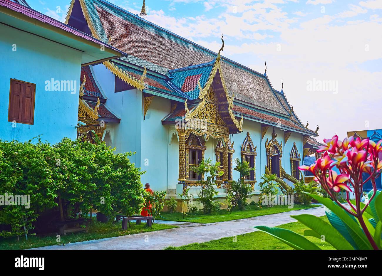 Ornate side wall of the viharn of Wat Chiang Man temple, surrounded with garden beds, Chiang Mai, Thailand Stock Photo