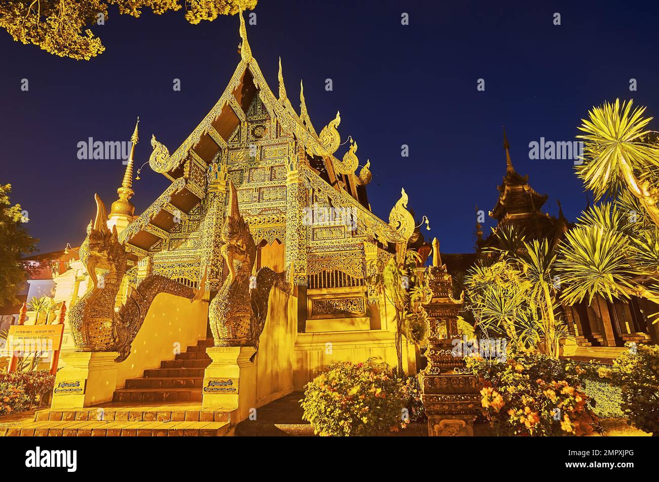 The carved wooden facade of the medieval Bhuridatto Viharn of Wat Chedi Luang, decorated with inlay, fine floral patterns, pyathat roof and statues of Stock Photo