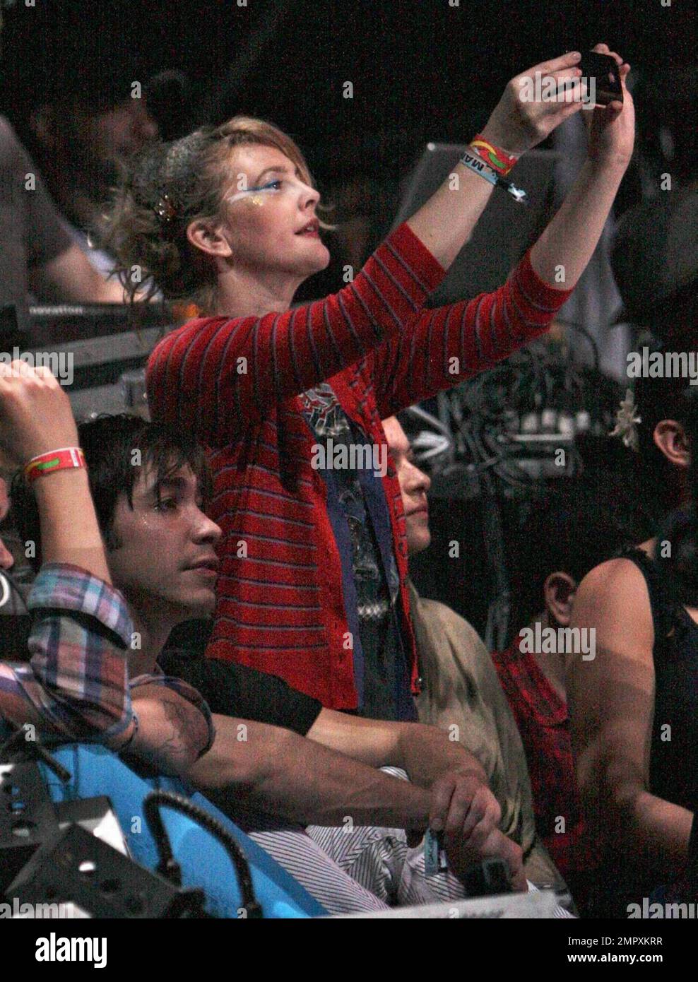 Drew Barrymore and recently reconciled boyfriend Justin Long watch the M.I.A concert.  Long took pictures of Barrymore on his iphone before she appeared up onstage during the concert throwing glow sticks into the audience at Coachella Music and Arts Festival 2009. Indio,CA. 04/18/2009. Stock Photo