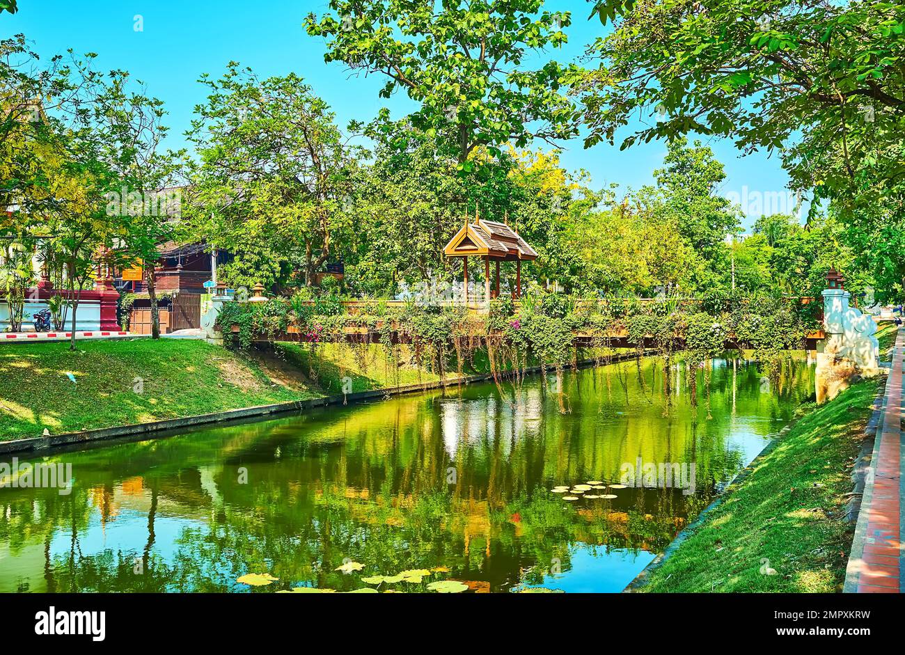 Walk along the medieval moat with niice small footbridges, decorated with wooden gate and hanging plants, Chiang Mai, Thailand Stock Photo