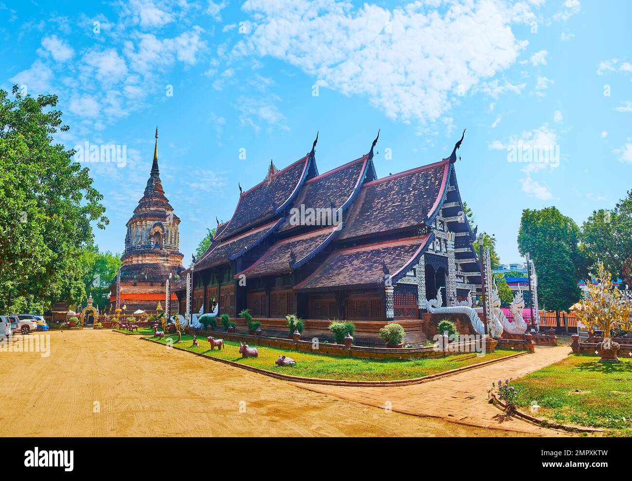 Panorama of the teakwood Viharn with pyathat roof and the ancient Lanna style Chedi in background, Wat Lok Moli, Chiang Mai, Thailand Stock Photo