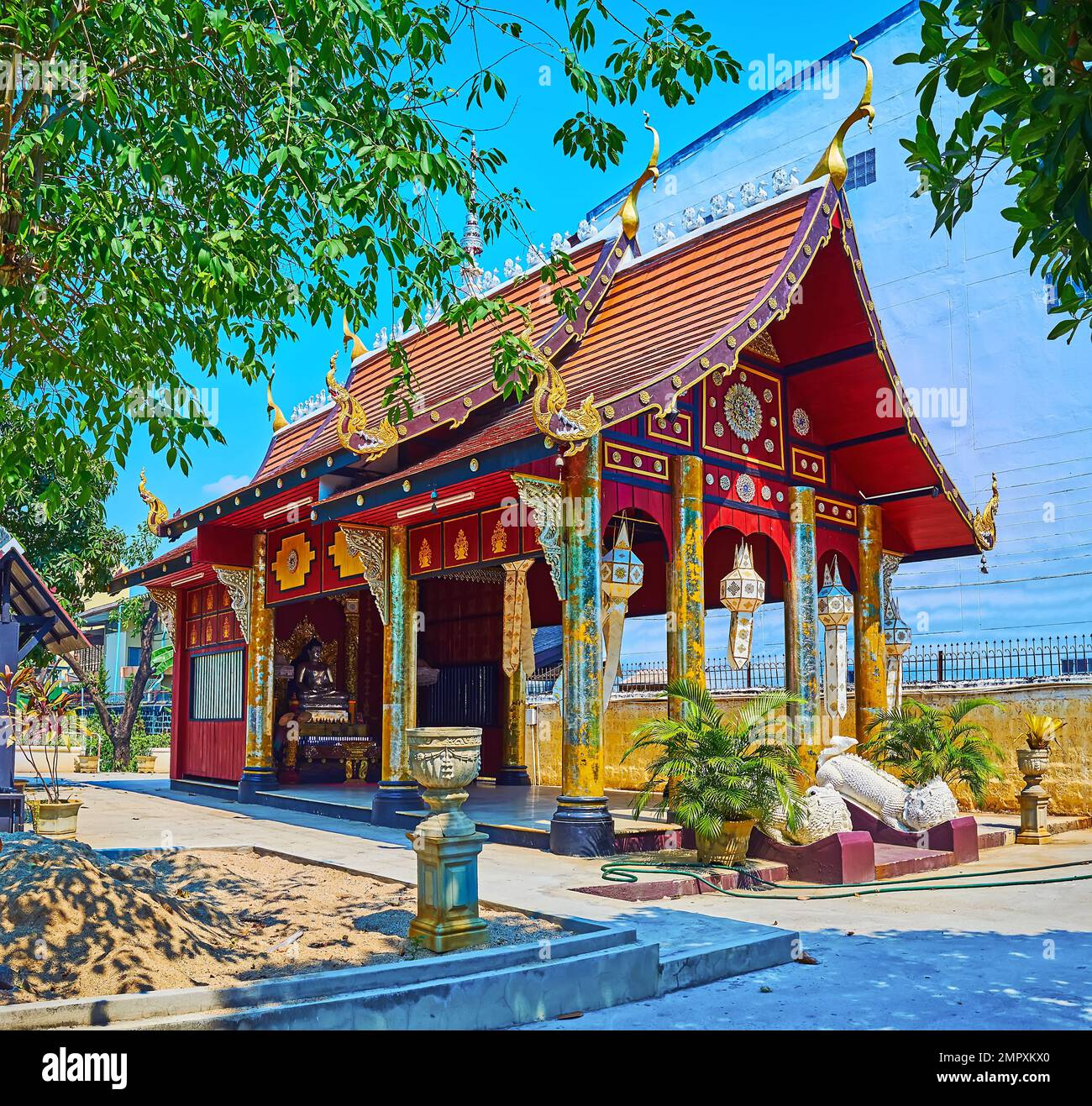 The tiny shrine of a small Wat Hor Pra temple, decorated with gilt columns, pyathat roof, Lanna lanterns and Buddha Image inside, Chiang Mai, Thailand Stock Photo