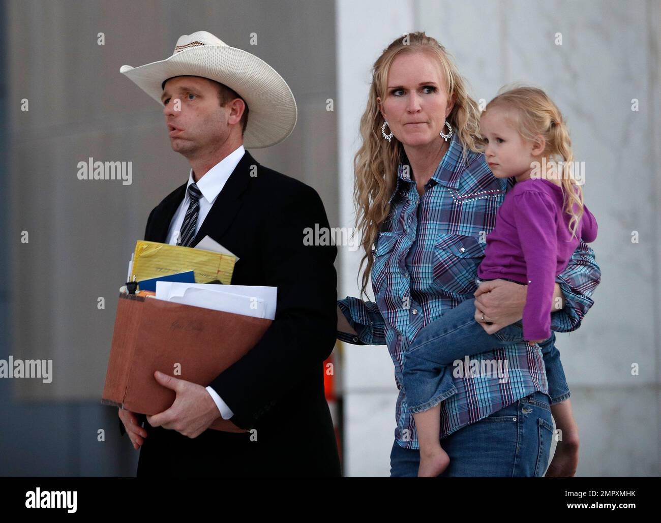 Ryan Bundy, left, walks out of federal court with his wife Angela Bundy,  Tuesday, Nov. 14, 2017, in Las Vegas. Ryan Bundy, along with his father  Cliven Bundy, brother Ammon Bundy, and