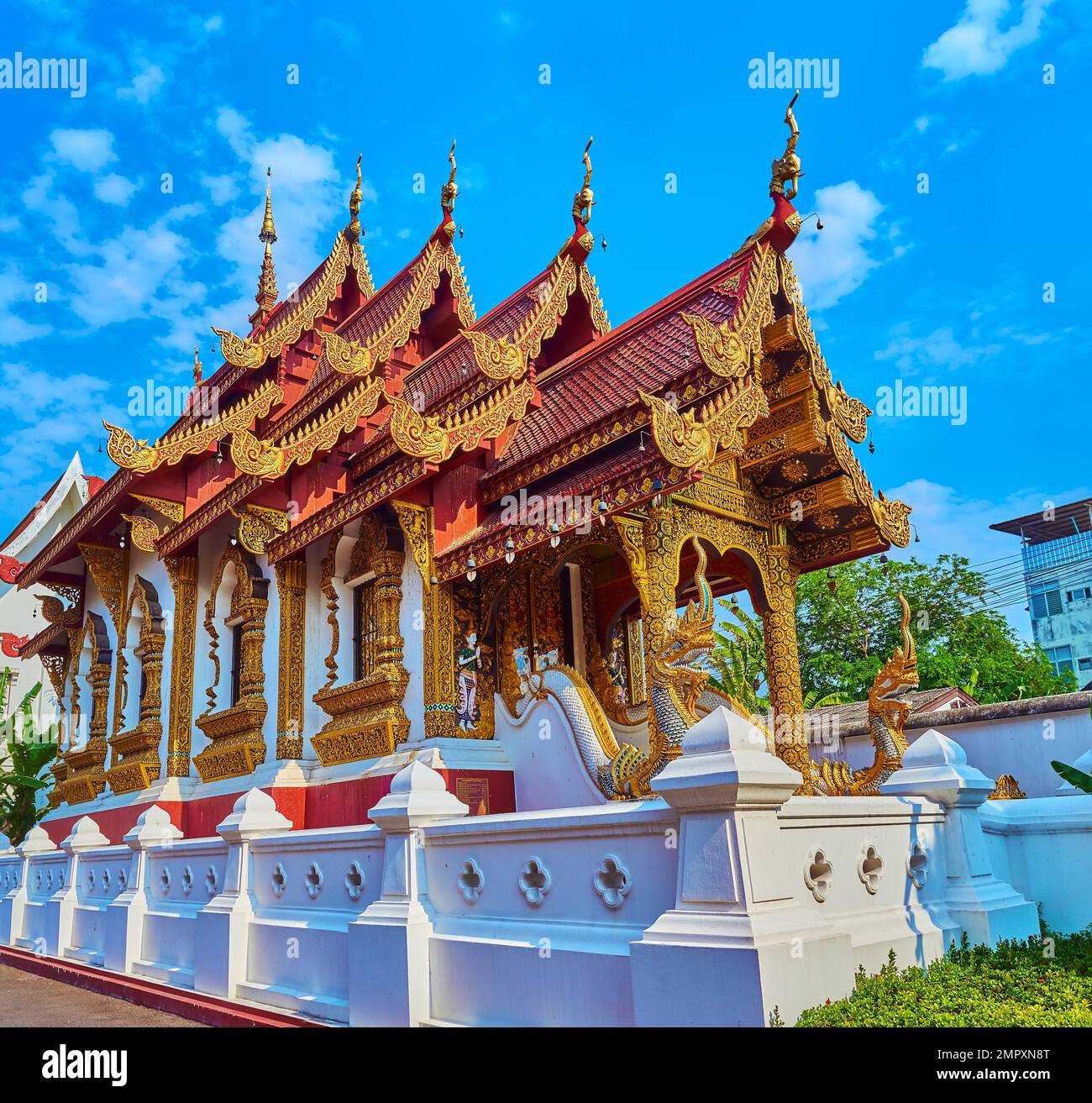 Exterior of Ubosot of Wat Saen Muang Ma temple with Naga serpent sculptures, moulding, gilt patterns, pyathat roof, Chiang Mai, Thailand Stock Photo
