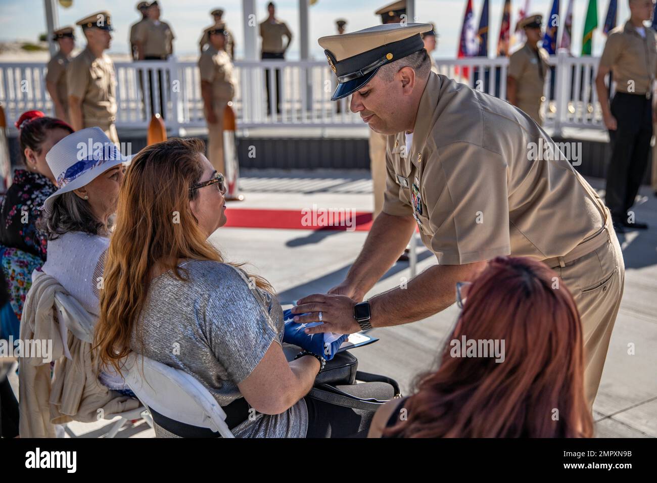 221122-N-YN807-10050 NAVAL AIR STATION NORTH ISLAND, Calif. (Nov 22, 2022) Senior Chief Aviation Ordnanceman (AW/SW) Jorge E. Maldonado, assigned to The Center for Naval Aviation Technical Training (CNATT),  presents the ensign to his wife during his retirement ceremony  at Naval Air Station North Island, Nov 22, 2022. CNATT is tasked with developing and maintaining the Sailor/Marine Training Continuum for Navy and Marine Corps aviation technical training. Stock Photo