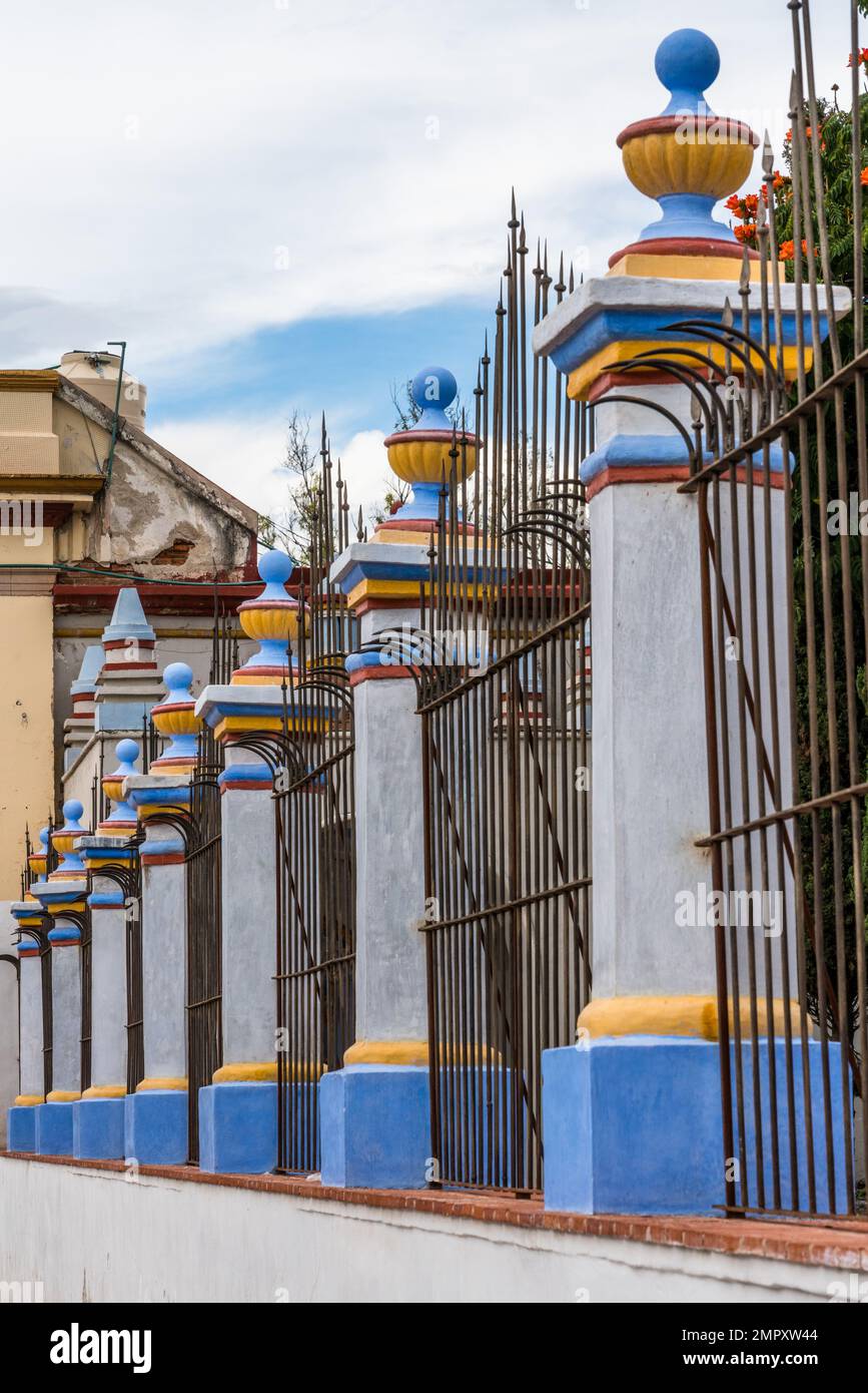 The wrought iron fence and colorful pillars in front of the Church of Santo Domingo in Ocotlan de Morelos, Oaxaca, Mexico. Stock Photo