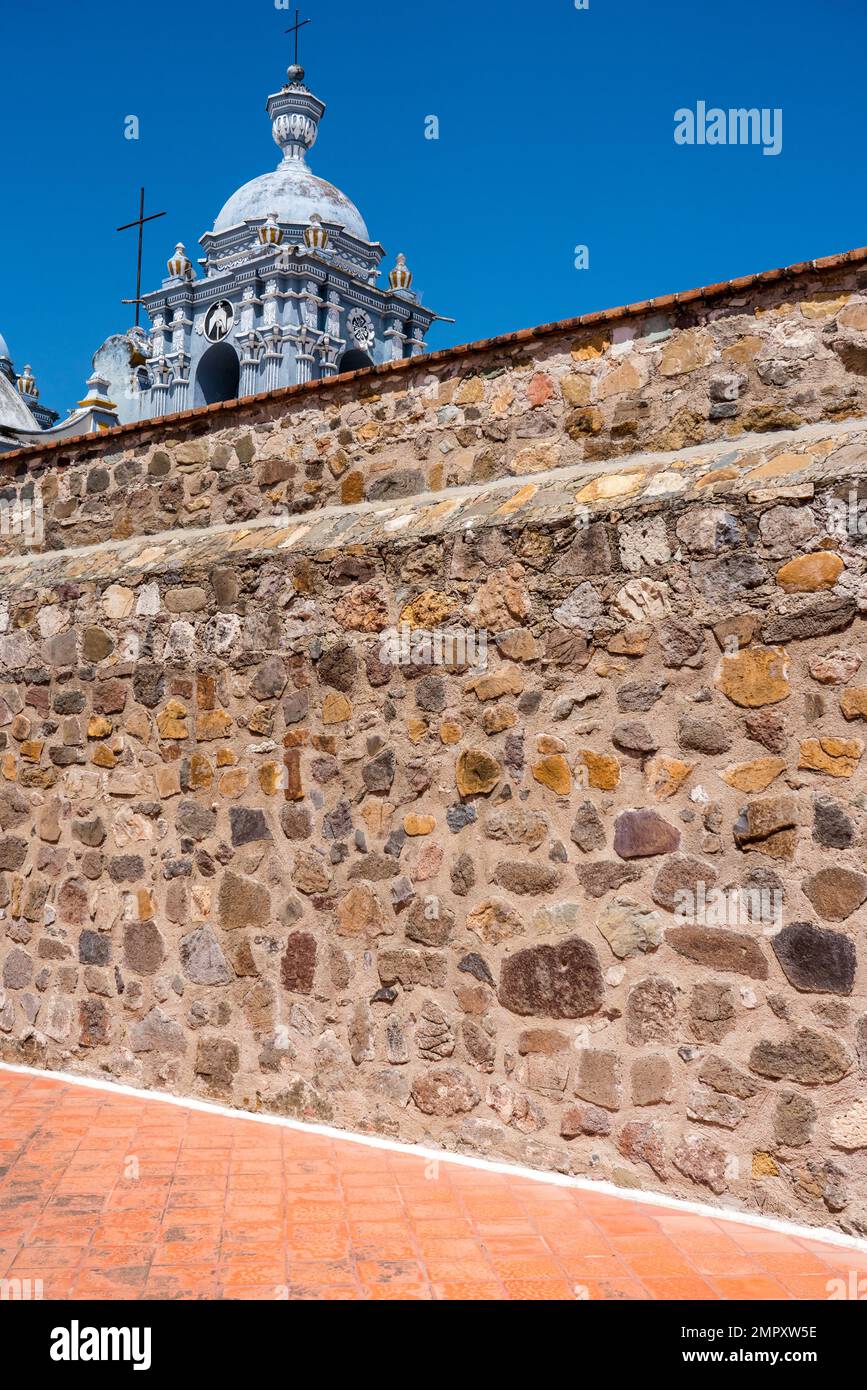 Bell tower of the Church of Santo Domingo de Guzman in Ocotlan de Morelos, Oaxaca, Mexico with the top of the monastery in front. Stock Photo