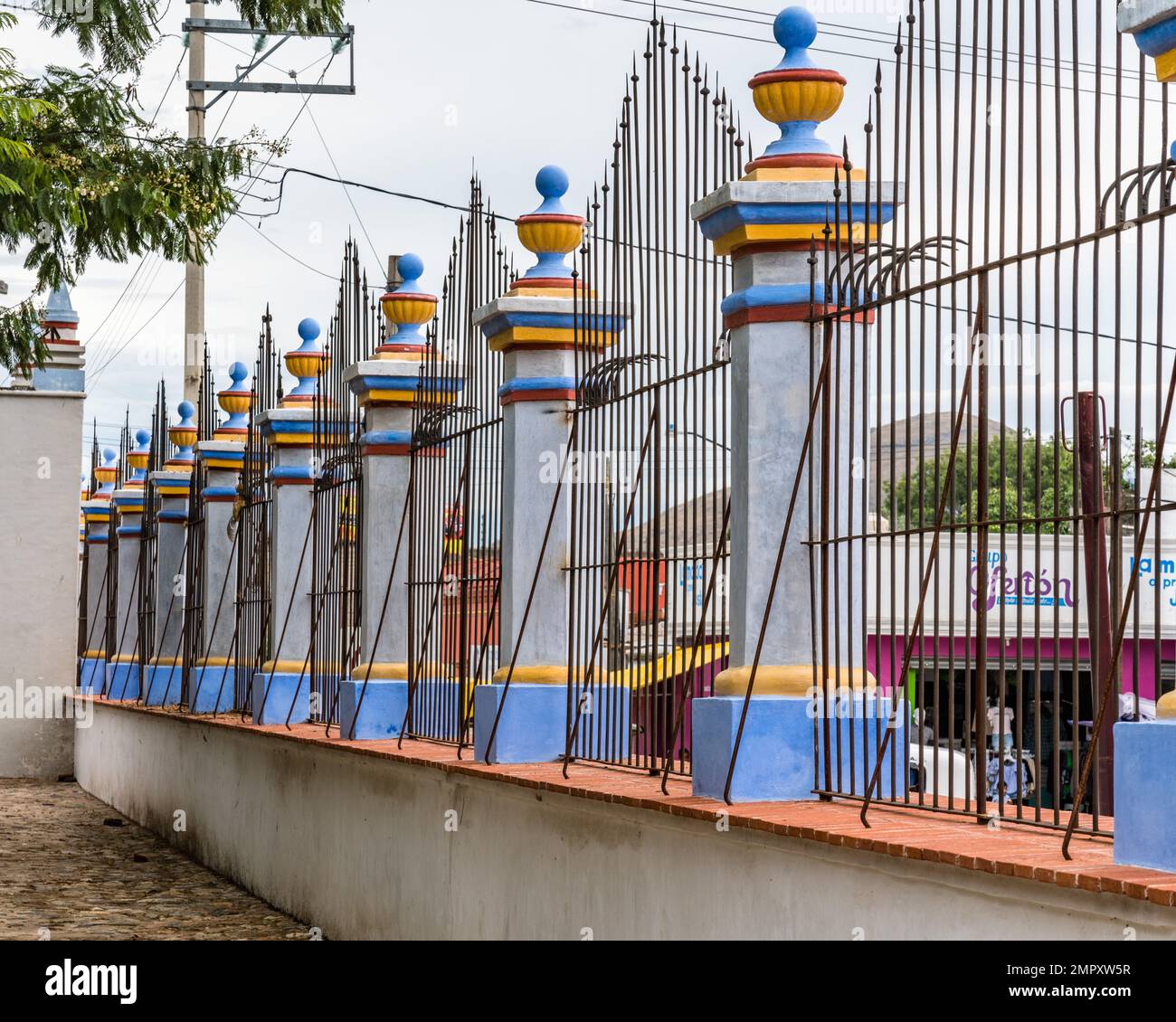 The wrought iron fence and colorful pillars in front of the Church of Santo Domingo in Ocotlan de Morelos, Oaxaca, Mexico. Stock Photo