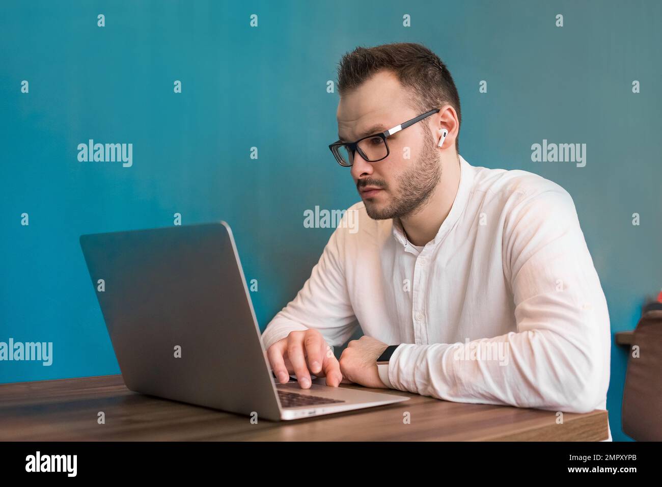 Giovane uomo in tuta che chiama cameriere al ristorante, mentre tablet e  caffè con il cellulare tenuto sul tavolo da pranzo Foto stock - Alamy