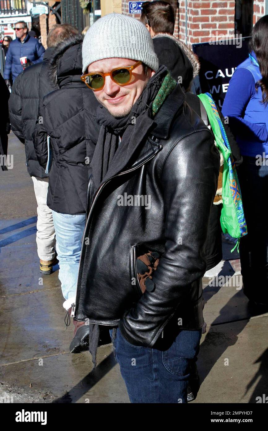 EXCLUSIVE!! Elijah Wood, who is set to play Frodo Baggins in 'The Hobbit,' keeps warm in a grey cap, black scarf and black leather jacket while out and about on day one of the Sundance Film Festival in Park City, UT. 1/20/11. Stock Photo
