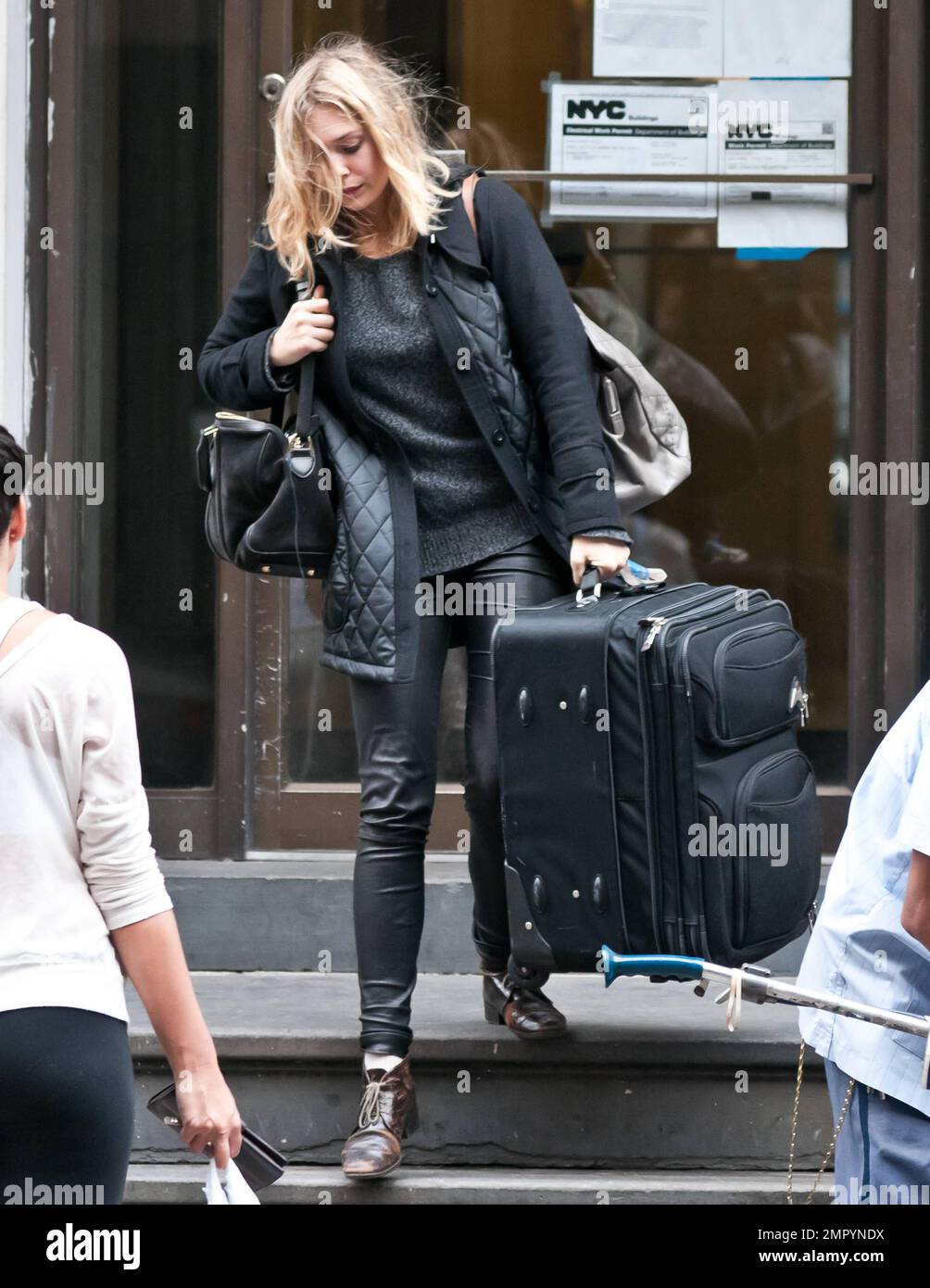 Actress Elizabeth Olsen, younger sister to famous twins Mary-Kate Olsen and Ashley Olsen, was seen departing her West Village apartment with luggage in hand as she made her way to the airport to catch a flight to Los Angeles. It's been reported that Elizabeth has become an overnight starlet with her lead debut in 'Martha Marcy May Marlene' which premiered earlier this week at the New York Film Festival. The film has a limited release date of October 21st and is already generating Oscar buzz. New York, NY. 13th October 2011.   . Stock Photo