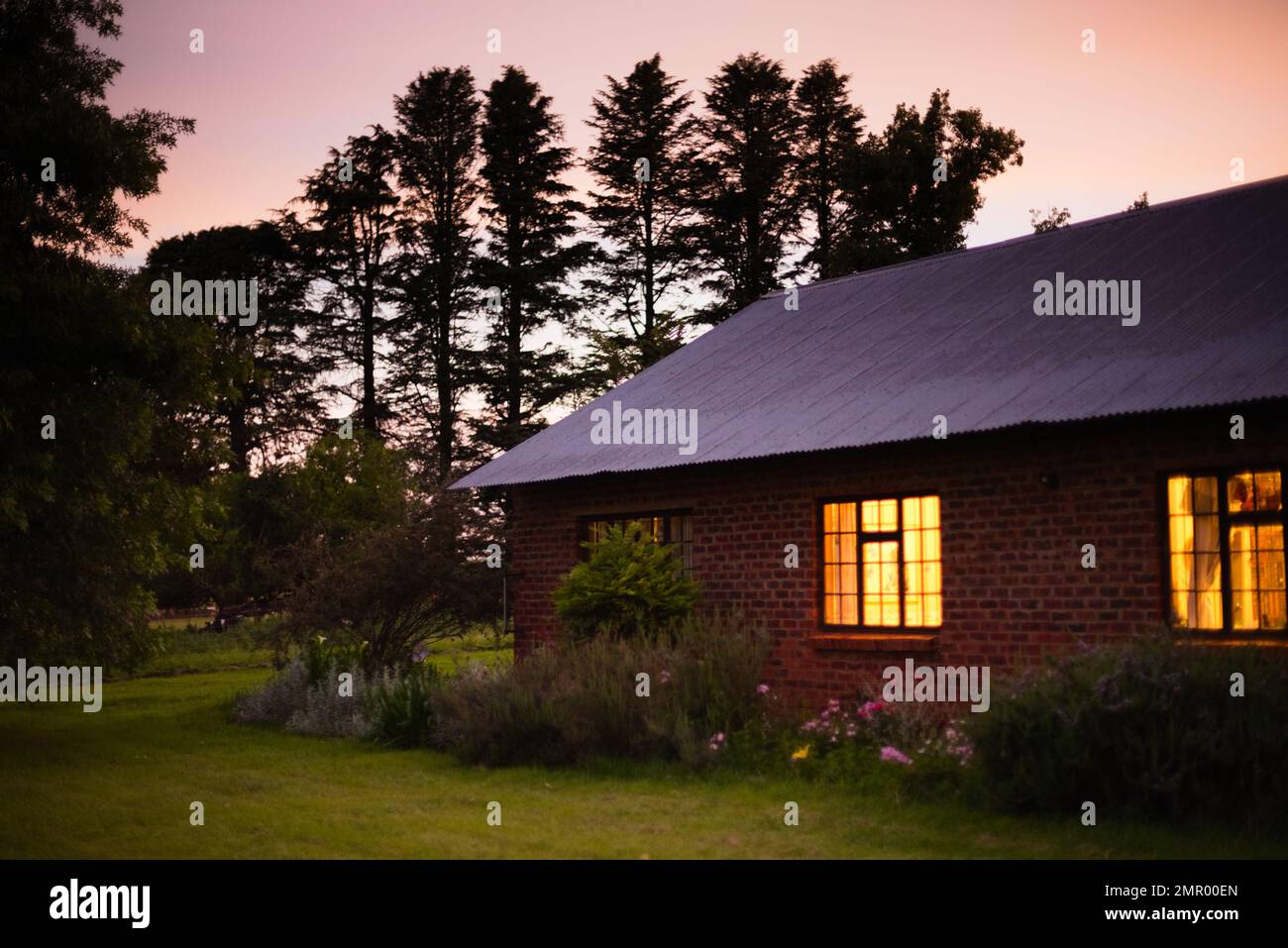 Farmhouse and gardens at dusk in the Berg,/ Drakensberg, South Africa ...