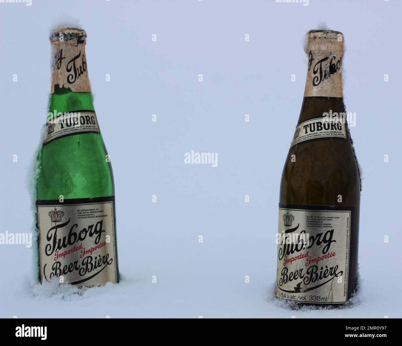 Two old Tuborg beer bottles from Denmark chilled in the snow. Stock Photo