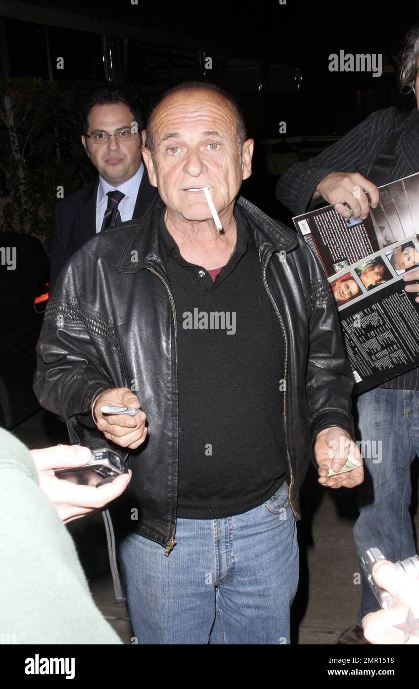 Exclusive!! Joe Pesci and Angie Everhart leave the restaurant AGO. Everhart makes her way quickly to the waiting car, hiding her face as much as possible, but Pesci smokes a cigarette while signing autographs and taking photos with fans. Los Angeles, CA. 10/21/08. All Stock Photo