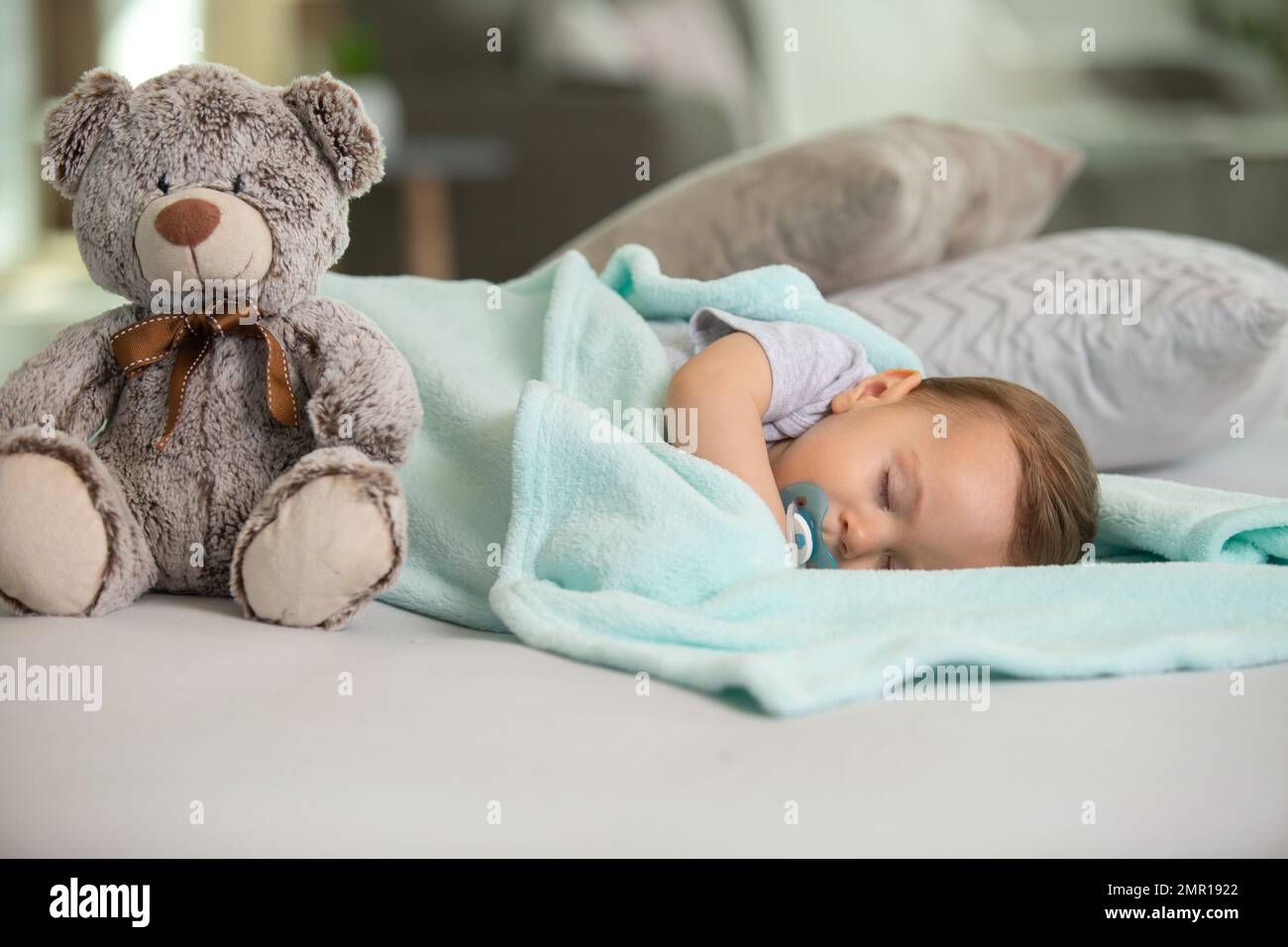 baby asleep with a dummy and a teddybear Stock Photo Alamy