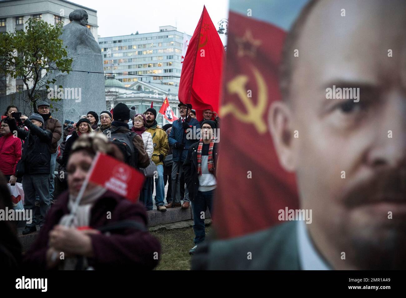 Communist party supporters stand next to a monument to Karl Marx, left ...