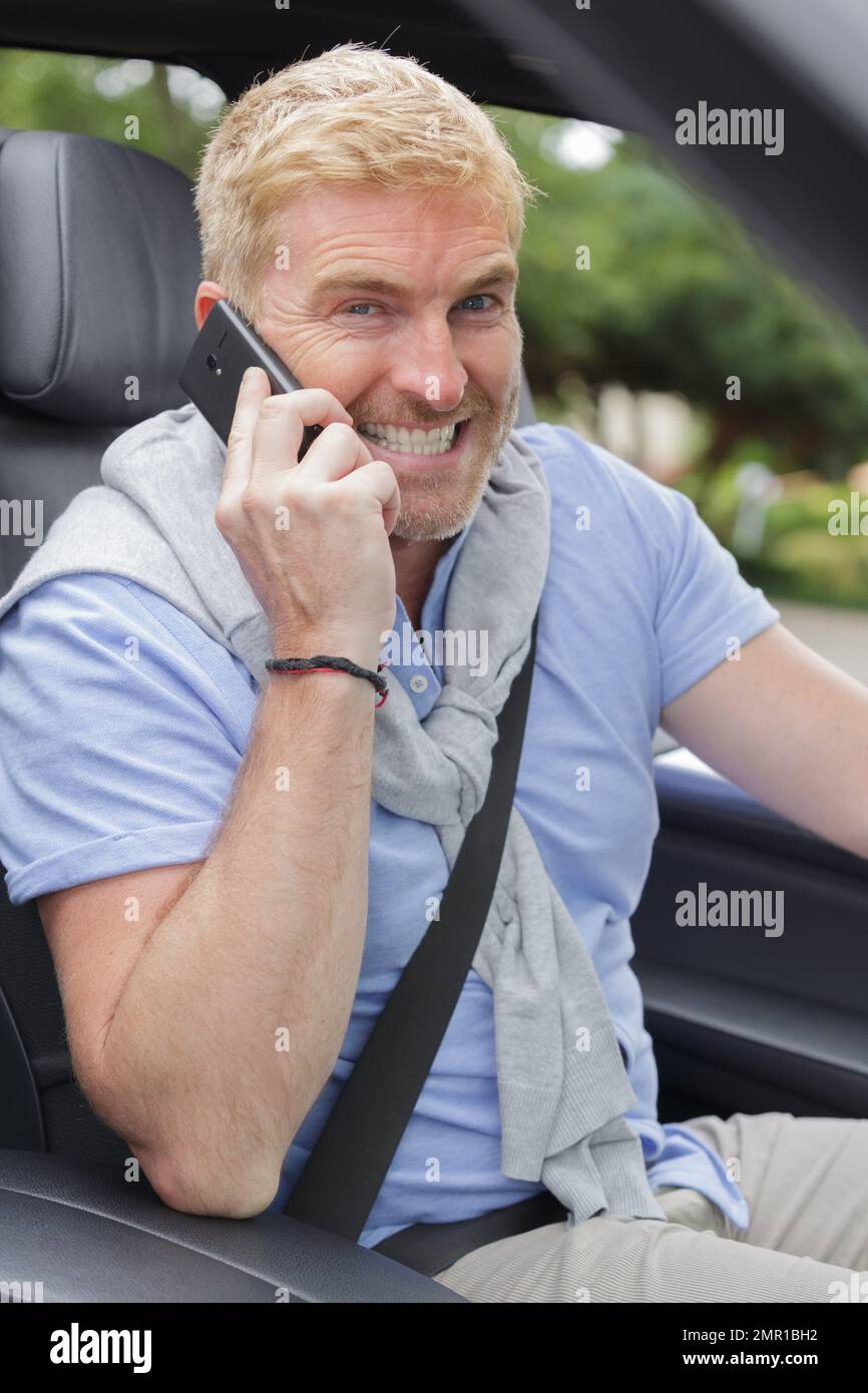 man behind wheel giggling while on phone Stock Photo - Alamy