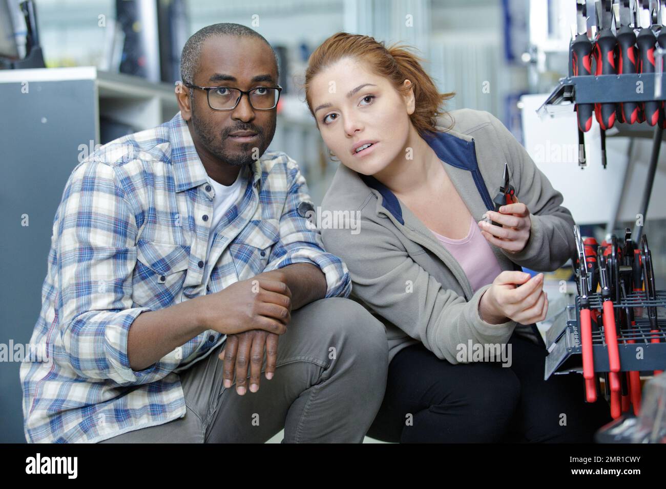 friendly african hardware store assistant helping young couple choosing