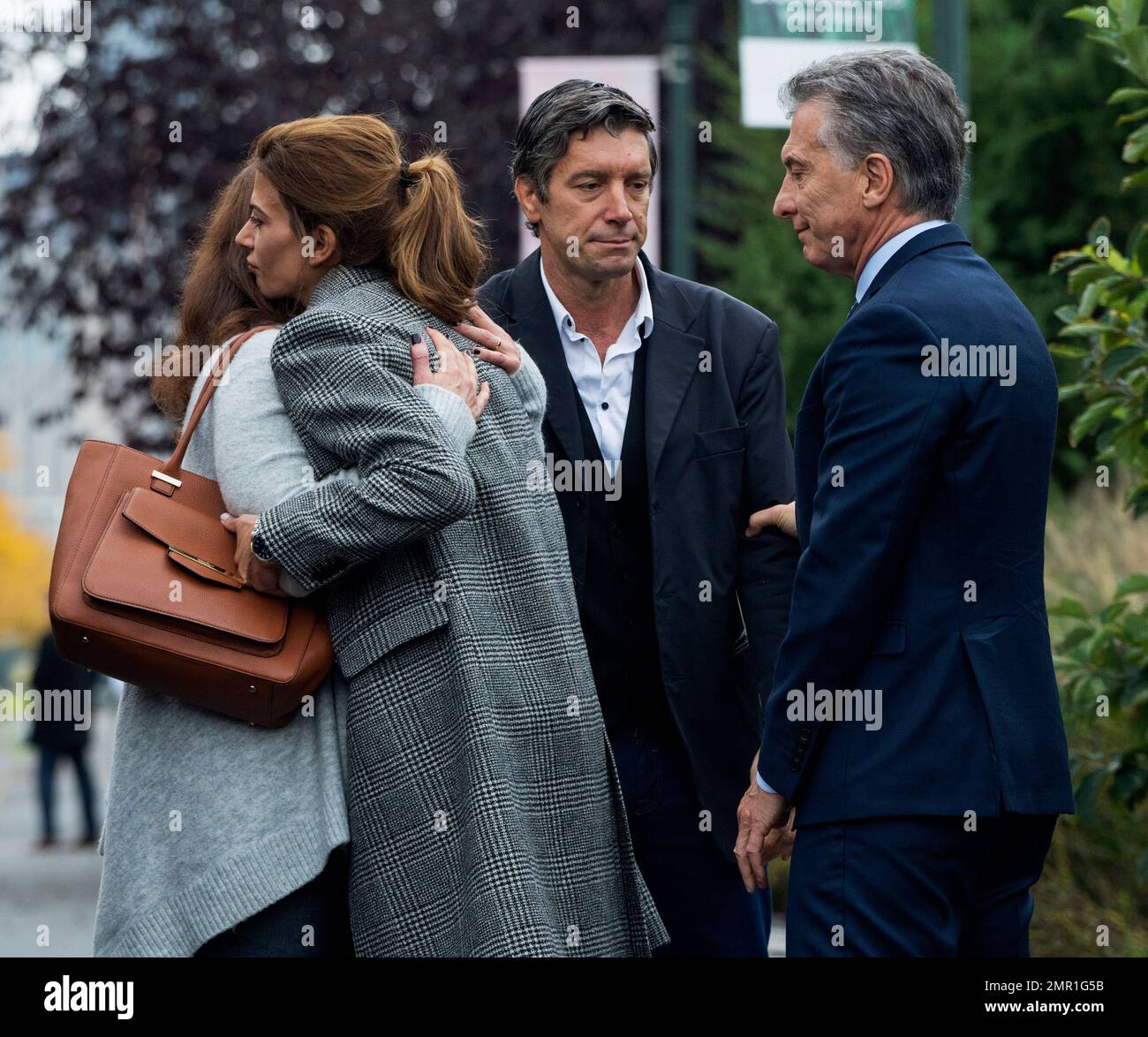 ADDS NAME OF MOURNER AS MARIANA DAGATTI - Mauricio Macri, President of Argentina, right, reaches out to bike attack survivor Guillermo Banchini as Marci's wife Juliana Awada, second from left, embraces Mariana Dagatti, wife of Martin Marro of Argentina who is still hospitalized while officials and others gather for a tribute Monday, Nov. 6, 2017, on the same bike where five citizens from Argentina where struck and killed in a terrorist attack Tuesday, Oct. 31, in New York. (AP Photo/Craig Ruttle) Stock Photo