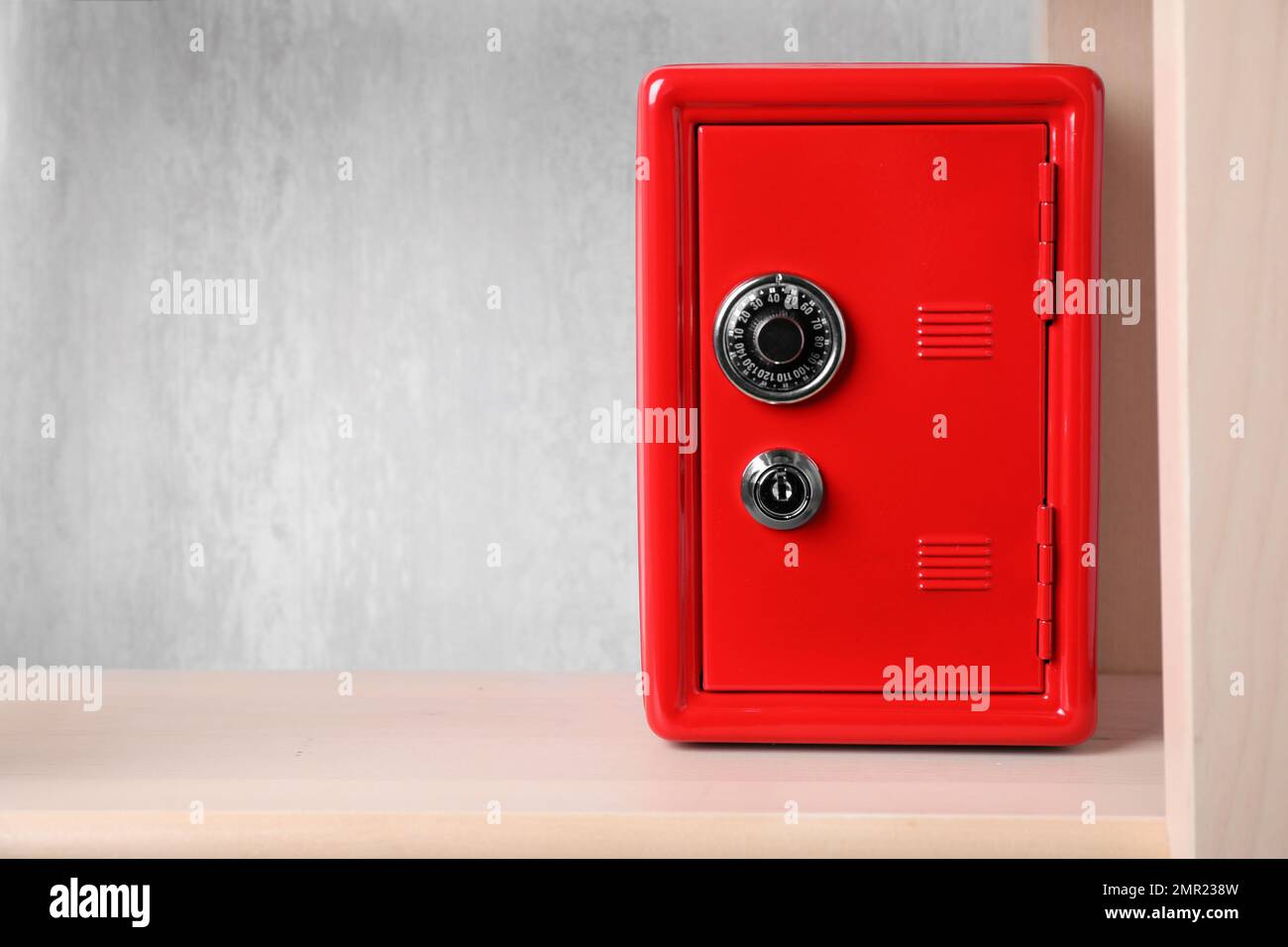 Red steel safe with mechanical combination lock on shelf. Space for ...