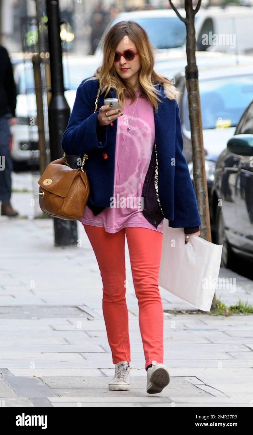 Wearing a tie-dye t shirt and red leggings with Converse All-Stars, Fearne  Cotton checks messages on her phone as she leaves BBC Radio 1. London, UK.  11/15/10 Stock Photo - Alamy
