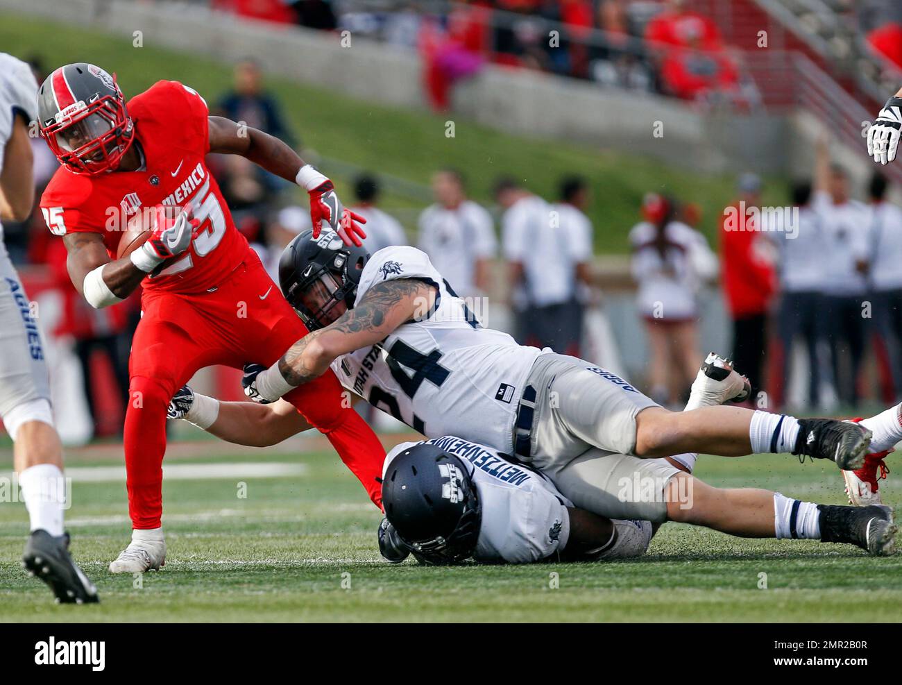 New Mexico running back Tyrone Owens (25) is stopped by Utah State