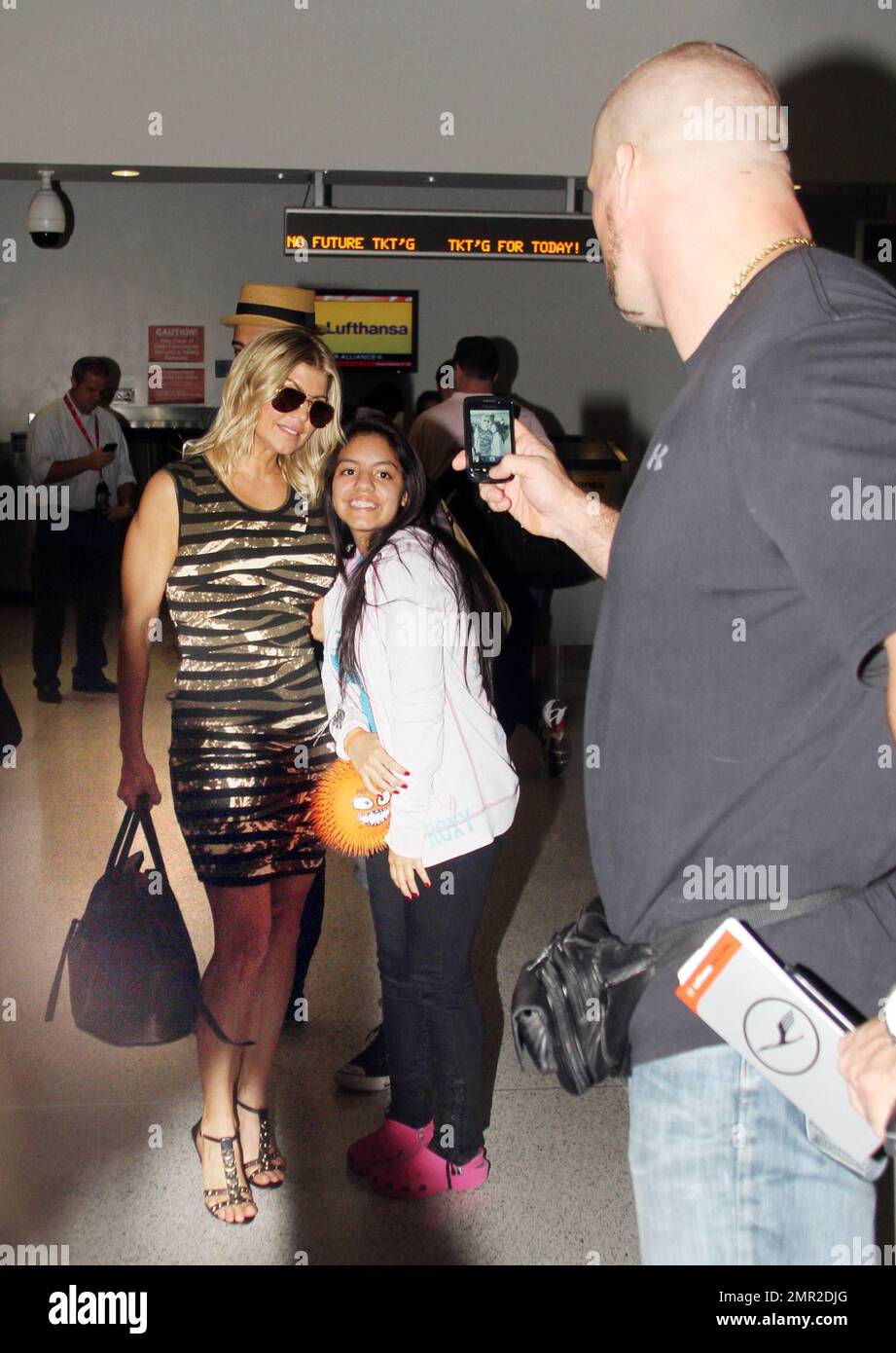 fergie showed off her incredible figure in a camouflage dress as she made her way through the airport accompanied by pals and security the singer stopped to pose for photos with fans before heading off to catch her flight she had been in town to support the dolphins a team she is part owner of in the season opener last night the dolphins lost but fergie still appeared to be in great spirits miami fl 13th september 2011 2MR2DJG