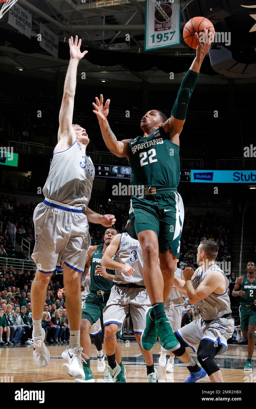 Michigan State's Miles Bridges, right, puts up a shot against Hillsdale
