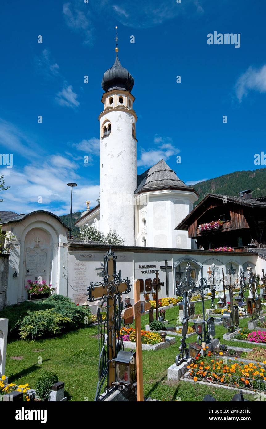 Cemetery and San Michael parish church with cylindrical bell tower in San Candido (Innichen), Pusteria Valley, Trentino-Alto Adige, Italy Stock Photo