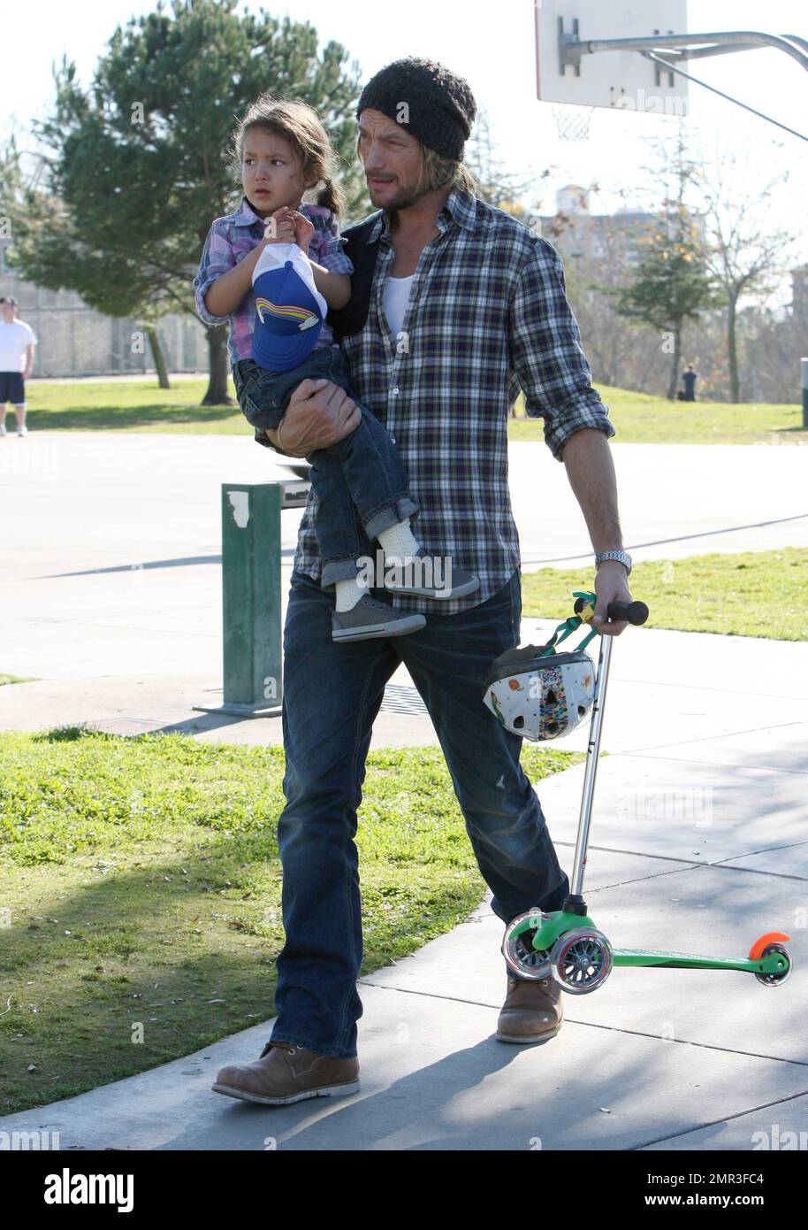 Wearing matching outfits, Gabriel Aubry and daughter Nahla spend a day together at a local playground. Joined by a friend, little Nahla played on the swings and her dad carried her while toting along her scooter and helmet. Aubry and Nahla's mom Halle Berry share legal custody, but it's reported that he lost the most recent battle after a judge refused his request to rescind a requirement that a nanny be present during his custody visits. Beverly Hills, CA. 28th December 2011. Stock Photo