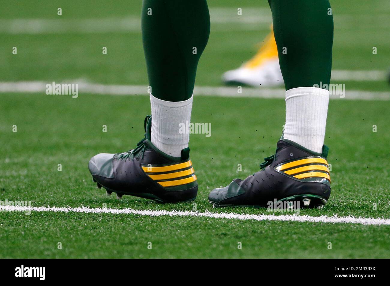 The cleats of Green Bay Packers' Aaron Rodgers (12) are detailed during an  NFL football game against the Dallas Cowboys on Sunday, Oct. 8, 2017, in  Arlington, Texas. (AP Photo/Roger Steinman Stock