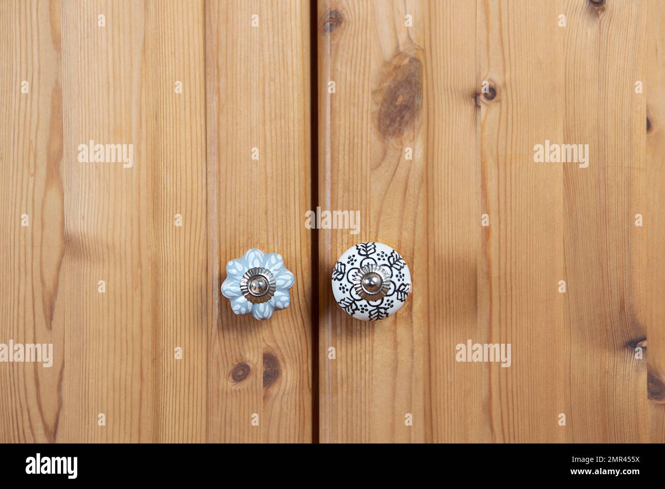Ceramic knob close-up by closed wooden wardrobe. Creative retro furniture decor background. Stock Photo